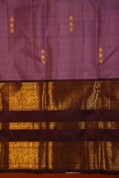 Close-up texture of the light burgundy pure handloom Kanjeevaram silk body featuring delicate gold zari buttis next to the elaborate maroon and gold gap border.