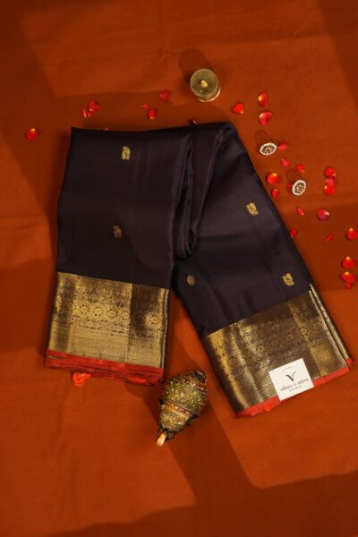 Draped outlook of the deep coffee brown pure handloom Kanjeevaram saree showcasing the striking contrast between the dark silk, gold zari border, and red edge.