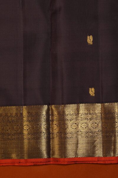 Detailed texture of the deep coffee brown pure handloom Kanjeevaram silk body featuring scattered gold zari Annapakshi bird motifs above the rich border.